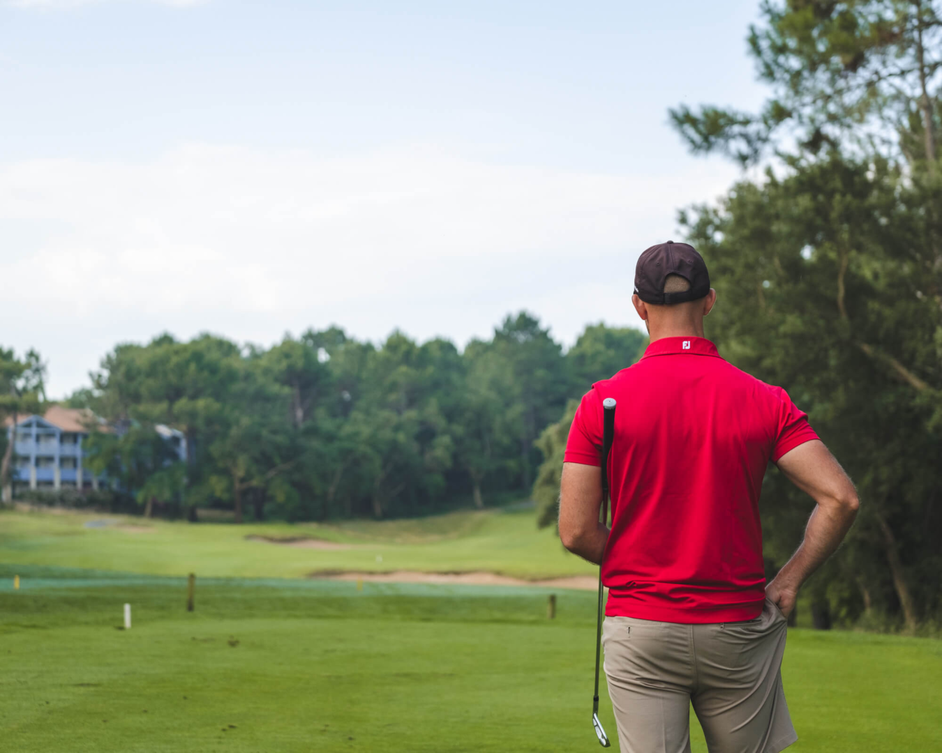 homme avec un t-shirt rouge qui joue au golf à Moliets et Maa