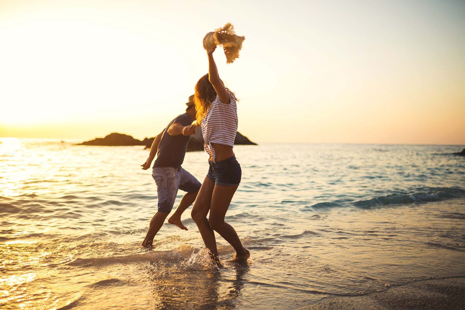 Young couple having fun by the sea,dancing and being happy