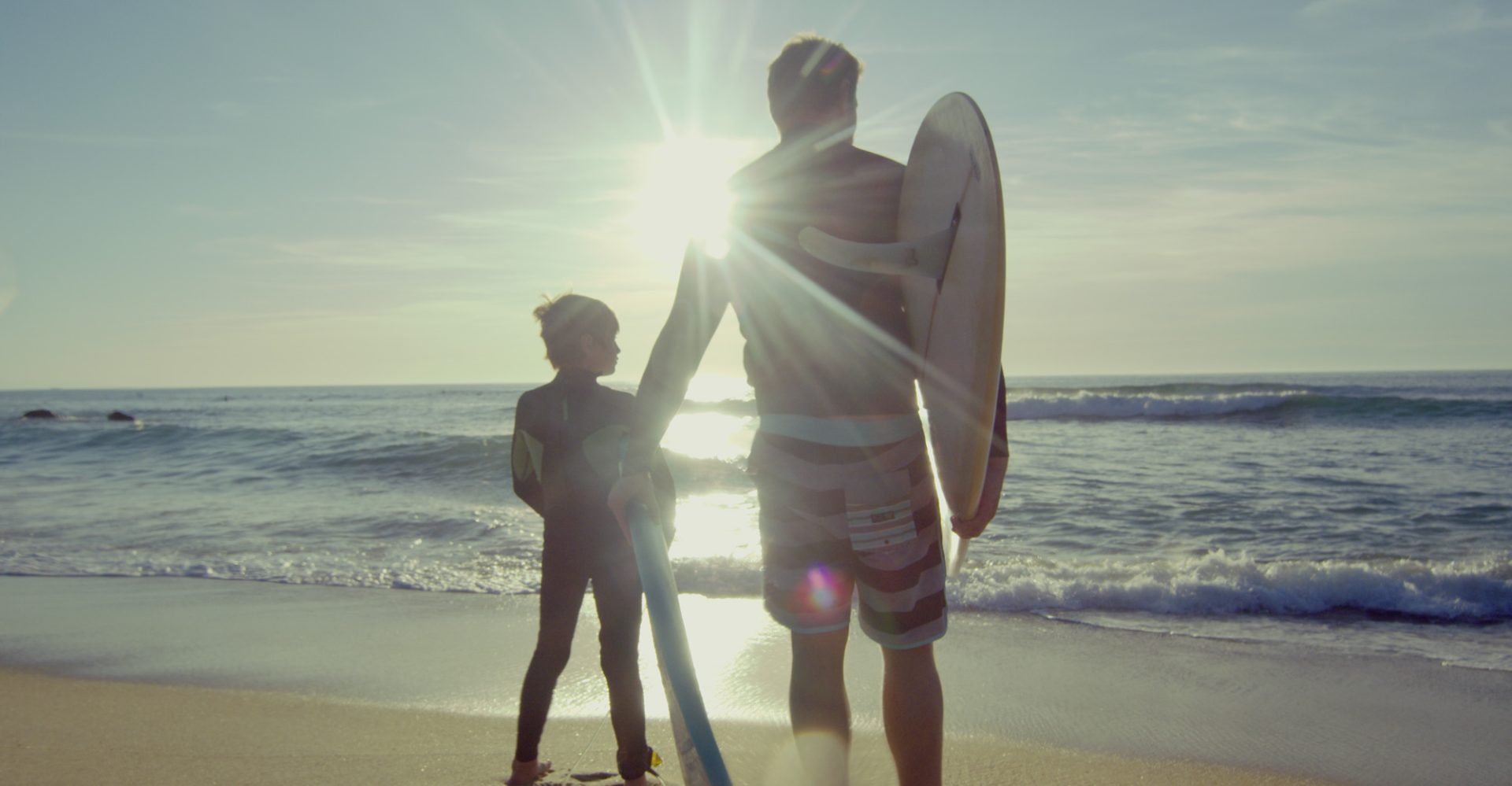 un père et son fils avec leurs planches de surf à Moliets
