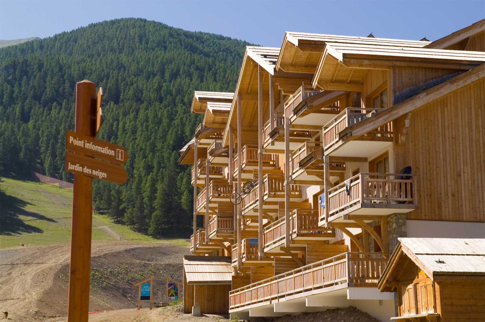 Image de la résidence Le Parc des Airelles de Madame Vacances : résidence de chalets en bois à la montagne, proche des pistes et du jardins de neiges, au cœur d'un paysage alpin verdoyant